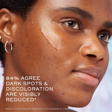 Woman with dark skin tone using Clarifique Pro-Solution Face Serum to help dark spots and discoloration 